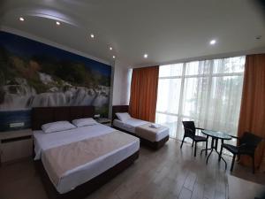巴统Hotel Royal Palace的酒店客房带两张床和一张桌子以及椅子。