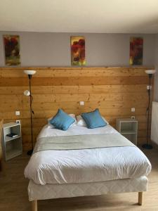 克吕特法国奥贝格酒店的一间卧室配有一张大床和两个蓝色枕头