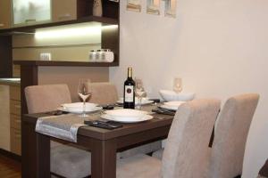 弗尔尼亚奇卡矿泉镇Perla Lux的餐桌、一瓶葡萄酒和椅子