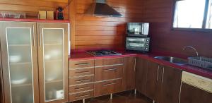 瓦伦西亚LA TRAMUNTANA CULLERA Playa Marenyet a 300 metros的厨房配有木制橱柜、水槽和微波炉
