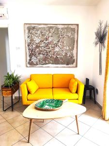 普拉托Il Melograno Apartment (Centro Storico Prato)的客厅里一张黄色的沙发,配有桌子