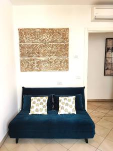 普拉托Il Melograno Apartment (Centro Storico Prato)的客房内的蓝色沙发,配有两个枕头
