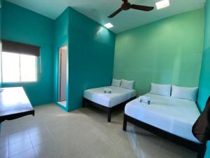 坎佩切Hotel Murallas Capital的蓝色的客房配有两张床和一张沙发