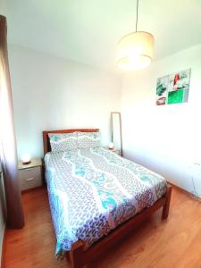 阿尔热祖尔Casa Rocha Relax的一间卧室配有一张带蓝色和白色棉被的床