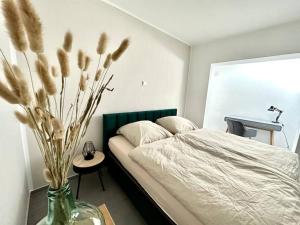 不来梅港Ferienwohnung komfortabel Wohnen Bremerhaven的一间卧室配有床和花瓶