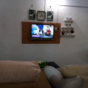 JeliRumah Tamu FieSari Jeli M U S L I M的带沙发和平面电视的客厅