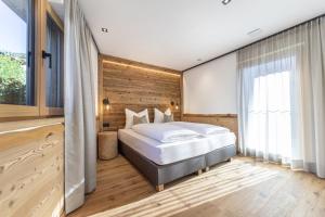 奥蒂塞伊Chalet Berna的一间卧室设有一张床和木墙