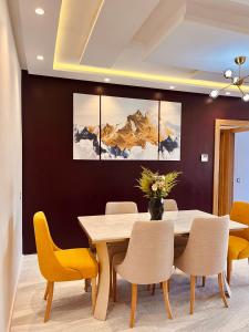 盖尼特拉Appartement moderne au décor raffiné的一间带木桌和黄色椅子的用餐室