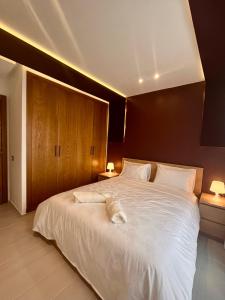 盖尼特拉Appartement moderne au décor raffiné的一间卧室配有一张带两盏灯的大型白色床。