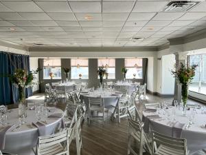 纽波特纽波特港码头酒店的宴会厅配有白色的桌椅