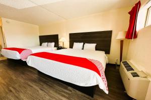 圣安东尼奥Oyo Hotel San Antonio Lackland AFB Seaworld Hwy 90 W的酒店客房带两张红色和白色的床单