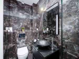 库瑞尼卡慕斯卡PORT 77的黑色浴室设有水槽和卫生间