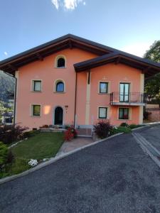 泰穆Appartamenti Flora Alpina的一座带车道的大型橙色房屋
