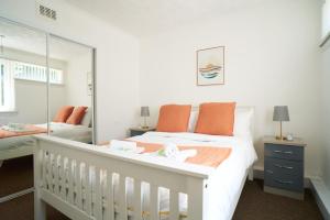 格拉斯哥Rotherwood Apartment的白色卧室配有婴儿床和镜子