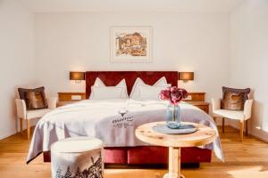 瓦尔贝拉瓦尔德豪斯酒店的一间卧室配有一张床和一张花瓶桌子