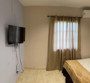 佩诺诺梅Brisas de Coclé的卧室设有壁挂式电视和床。
