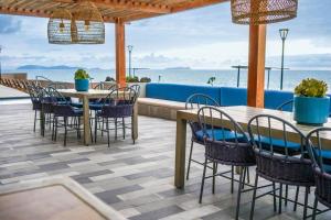 提华纳Hotel Suite Luxe Sunset的一个带桌椅的庭院和大海