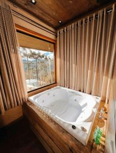 乌鲁比西Sunset Serrano Chalés的窗户客房内的大浴缸