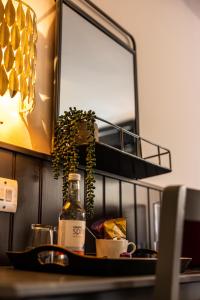 巴斯The Griffin Inn Bath的一张桌子,上面放着一瓶葡萄酒和一面镜子