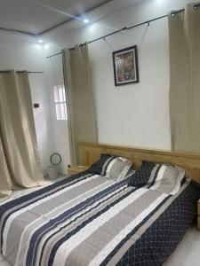 洛美Appartement Kekely的一间卧室配有带条纹毯子的床