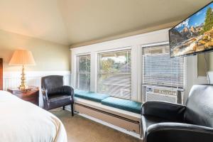 西雅图Seattle Gaslight Inn的卧室配有靠窗的座位、沙发和椅子