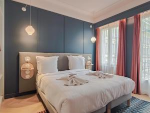 尼斯Aparthotel AMMI Nice Lafayette的一间卧室配有一张带蓝色墙壁的大床