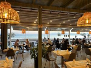 都拉斯Sea View Apartaments的一间设有桌子的餐厅,有坐在桌子上的人