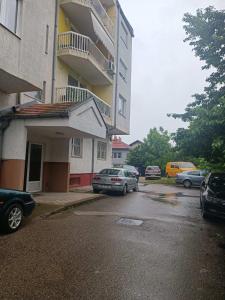 多博伊Doboj Apartman的停车场,停车场停在大楼前