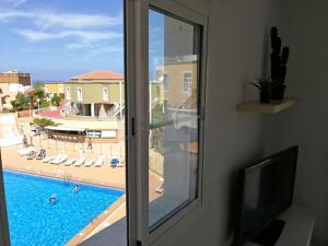 阿德耶Apartamento Costa Adeje - Orlando Complex的享有游泳池景致的窗户