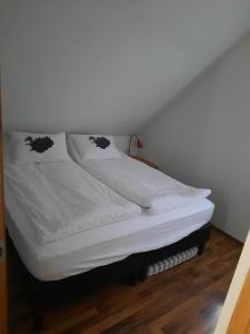 埃基斯蒂尔文兰小屋酒店的一张带白色床单和枕头的床