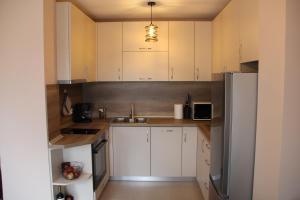 斯莫梁МОЯТ РАЙ - ПАДАЛОТО的厨房配有白色橱柜和不锈钢冰箱