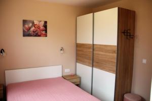 斯莫梁МОЯТ РАЙ - ПАДАЛОТО的卧室配有粉红色的床和橱柜。
