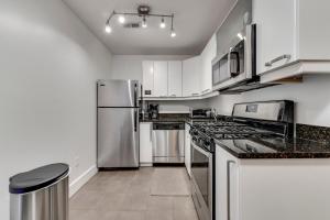 华盛顿Charming 2BD in Hip Neighborhood - 3 Blks to Metro的厨房配有白色橱柜和不锈钢用具