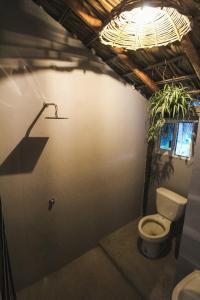 阿卡普尔科Kali Village的一间带卫生间的浴室和墙上的植物