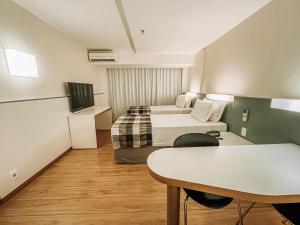 巴西利亚圣保罗广场酒店 的酒店客房设有两张床和一张桌子。