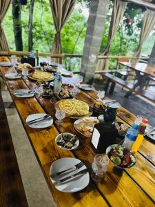 GachediliMartvili canyon cottage的一张长木桌子,上面放着食物盘