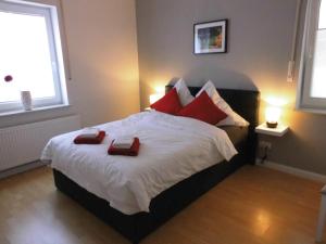 GoldenstedtHaus Holldack Wohnung Maria的一间卧室配有一张大床和两个红色枕头