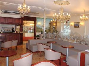卢尔德Hotel Du Gave的餐厅设有桌椅和吊灯。