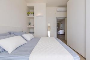 马鲁焦L'Attico di Alessia by BarbarHouse的一间卧室配有一张带白色和蓝色床单的大床