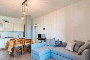 波尔佩纳泽德尔加尔达Relax by the pool - Garden - Garage的一间带蓝色沙发的客厅和一间厨房