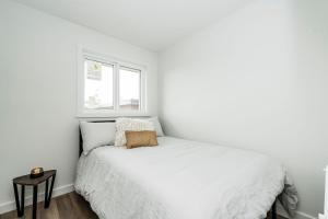ClairmontRNDup Urban Lofts的白色的卧室设有床和窗户