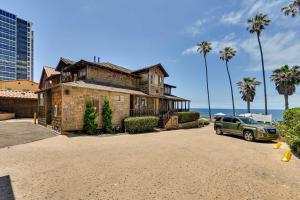 圣地亚哥Ocean-View La Jolla Condo Rental with Covered Patio!的一座古老的房子,前面有停车位