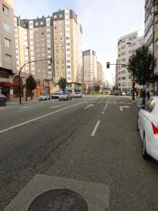 维戈La Ruta de las luces de Vigo的一条空荡荡荡的城市街道,有汽车和建筑