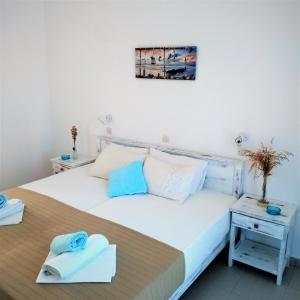 安迪帕罗斯岛Dolphin Rooms的卧室配有带毛巾的大型白色床