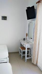 安迪帕罗斯岛Dolphin Rooms的客房设有带镜子的书桌和电视。