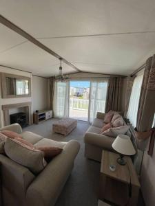 威尔汉姆2-6 guests Holiday Home in Durdle Door的客厅配有两张沙发和一张桌子