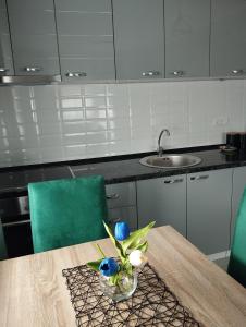 斯雷姆斯卡米特罗维察Apartman Green!!的厨房配有一张桌子,上面放着花瓶