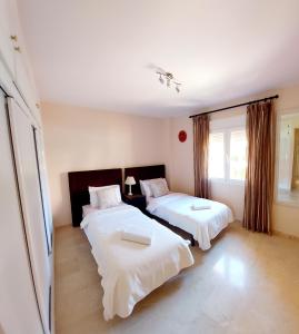 马拉加Luxurious Apartment 2 Bedroom 2 Bathroom Near Beach的一间卧室设有两张床和窗户。
