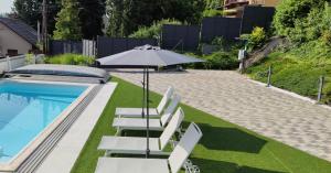 米什科尔茨AQUA SOLAR APARTMANHÁZ的一个带躺椅和遮阳伞的游泳池