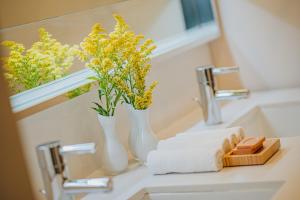 奥拉涅斯塔德Renaissance Wind Creek Aruba Resort的浴室水槽,上面有两瓶黄花花
